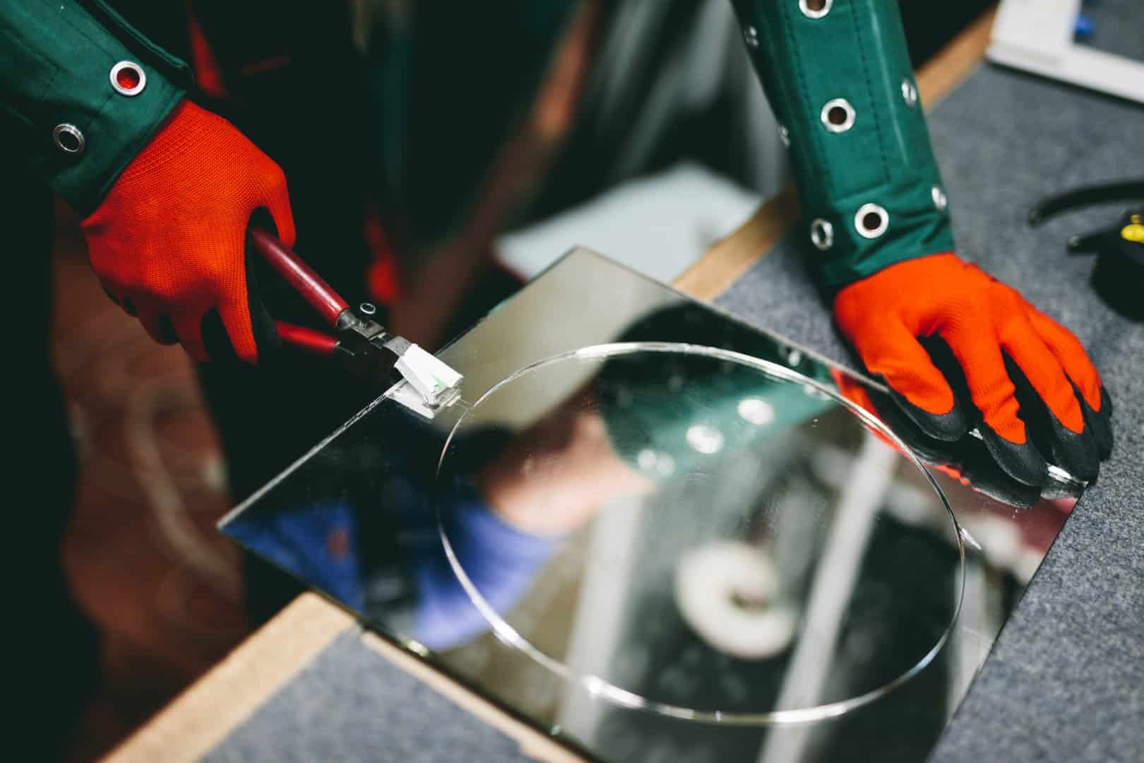 glazier worker cutting glass with compass glassLarge vitre sur mesure
